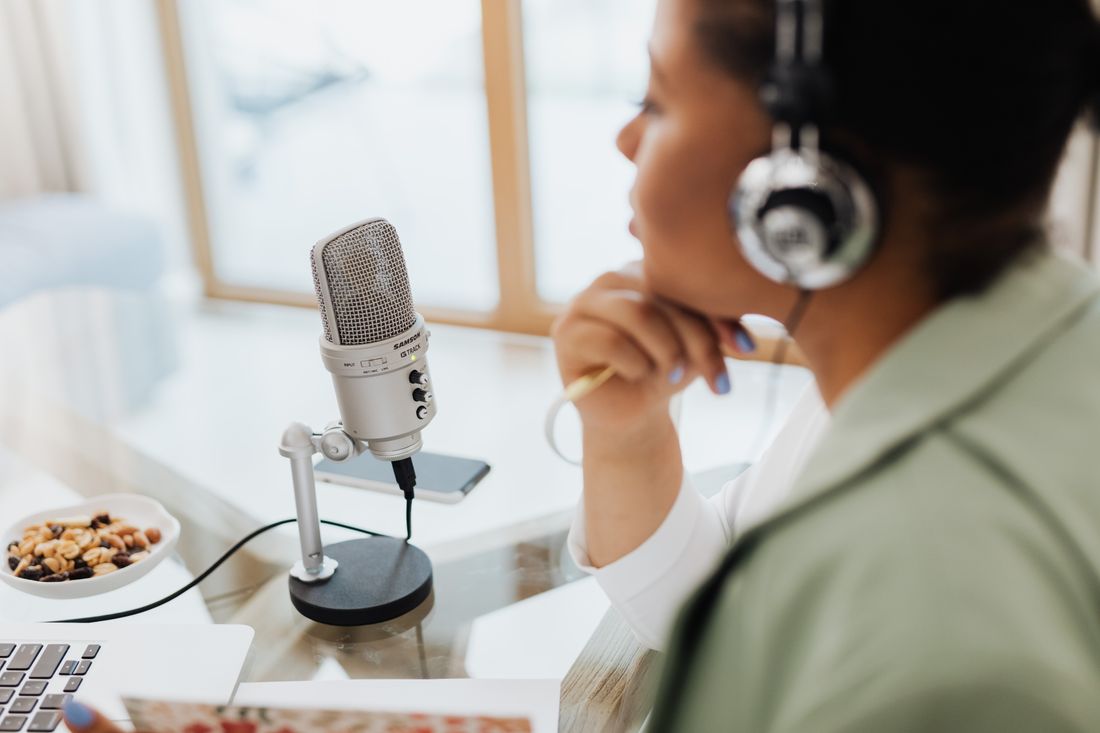 A partner recording at home with a microphone and laptop